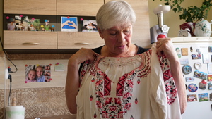 Leokadia WIlczyńska prezentuje bluzkę ręcznie haftowaną przez matkę Stefanię Wiktor.